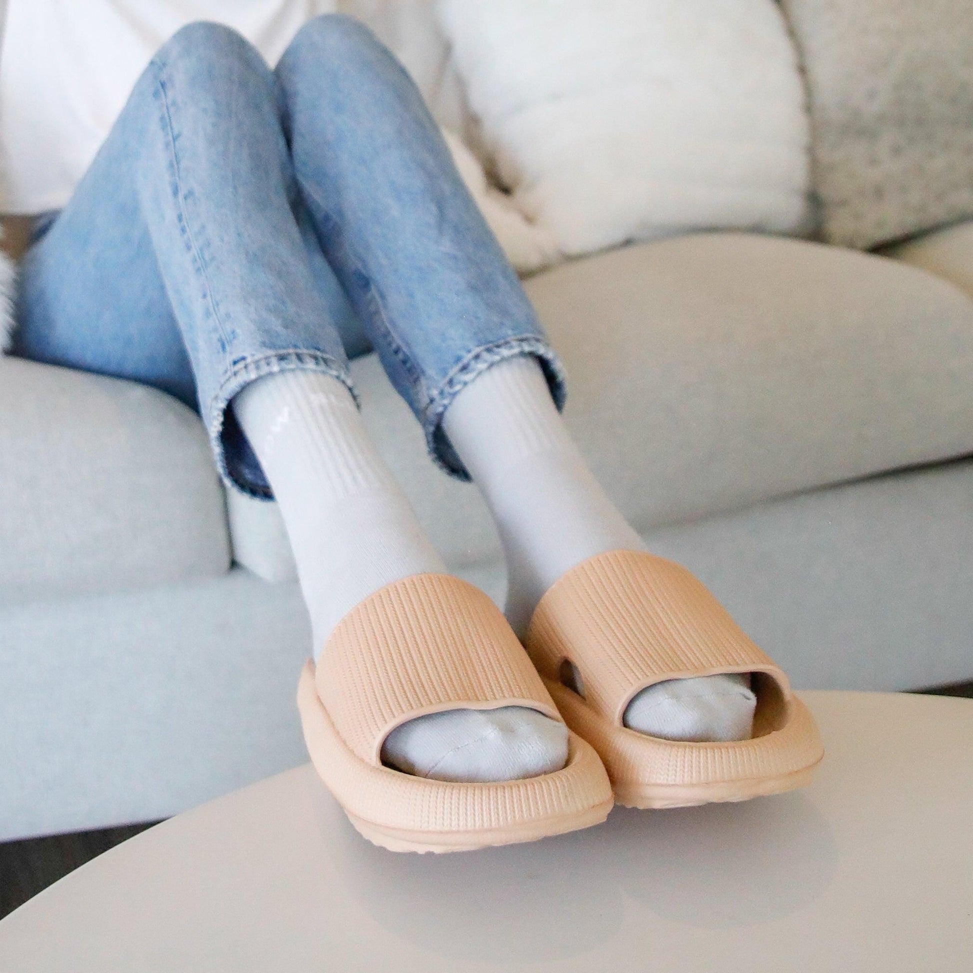 Grey socks in tan slippers on living room table