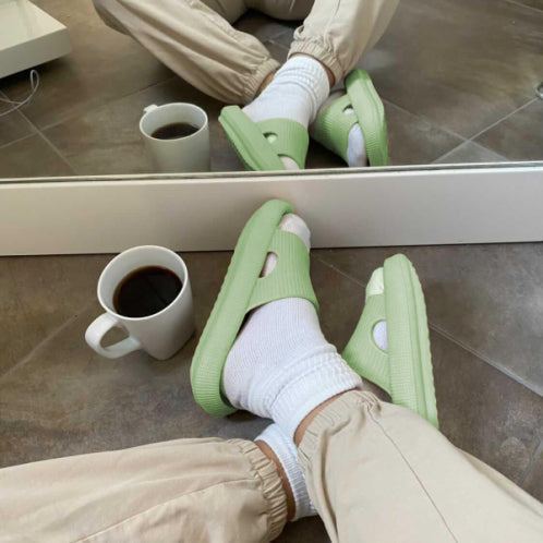 Trendy green slippers in front of mirror with coffee