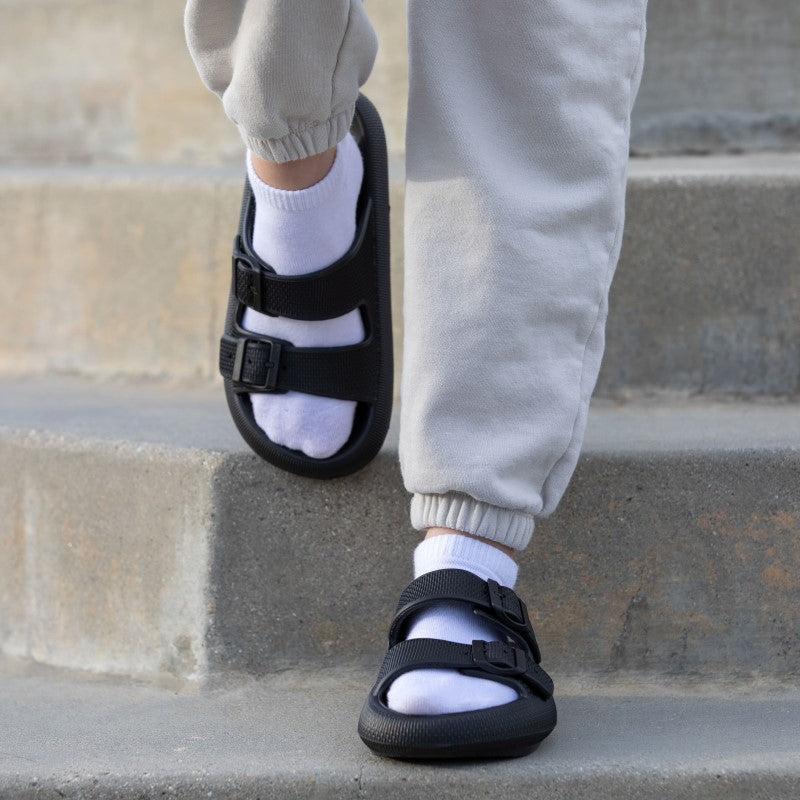 Women's black sandals on concrete stairs