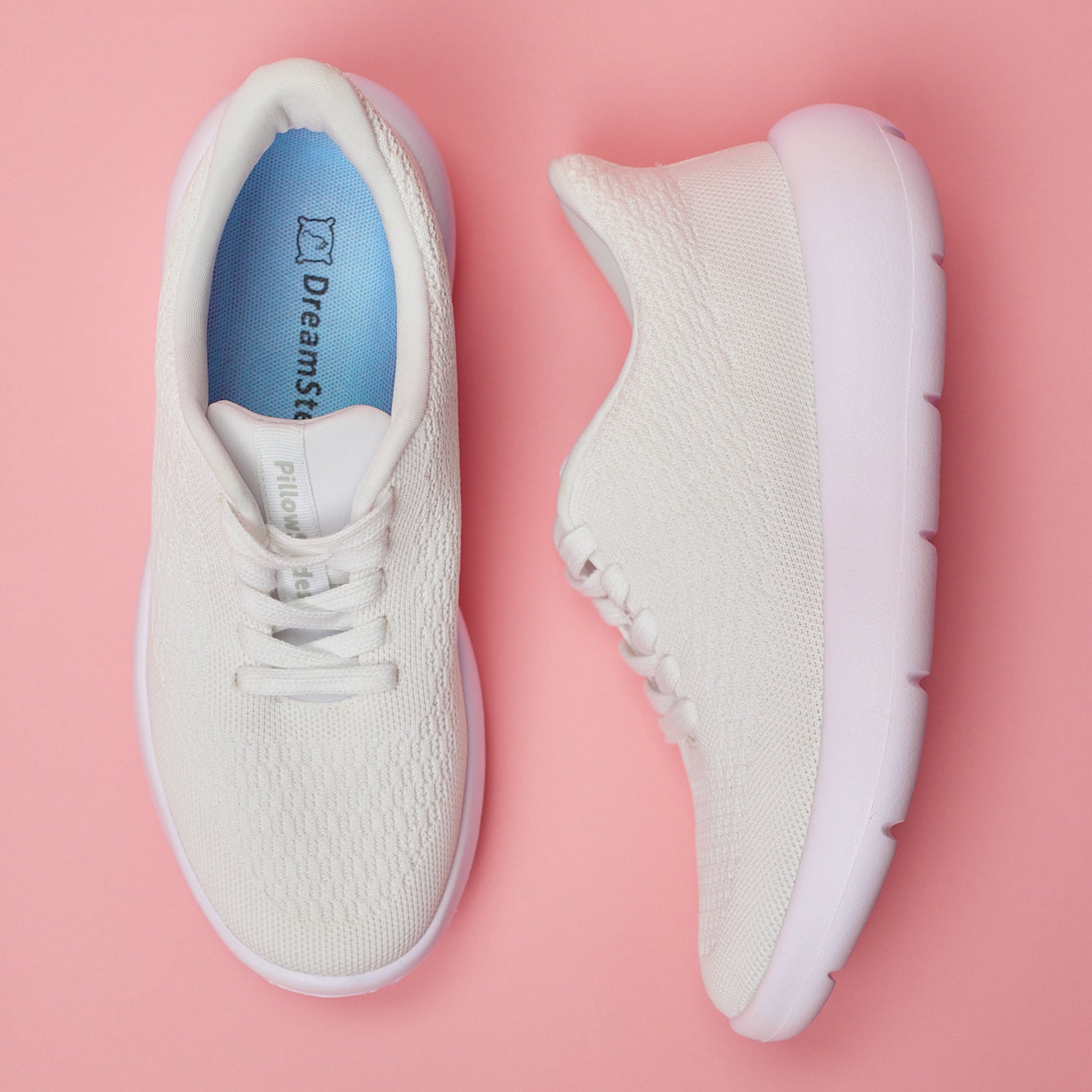 Stock white sneakers on a pink backdrop