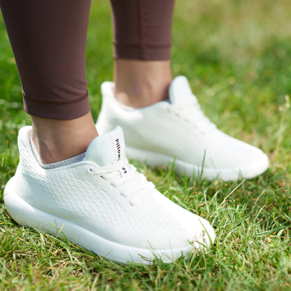 Women standing with white sneakers on grass