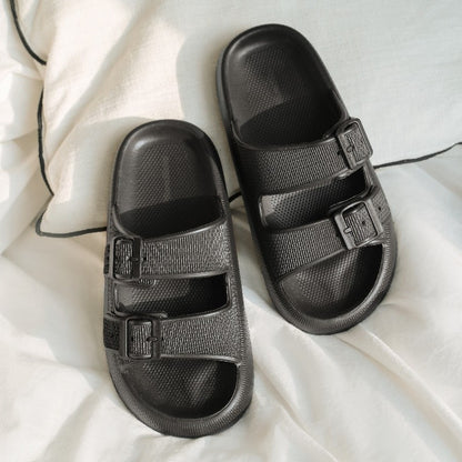 Women's black sandals on bedding