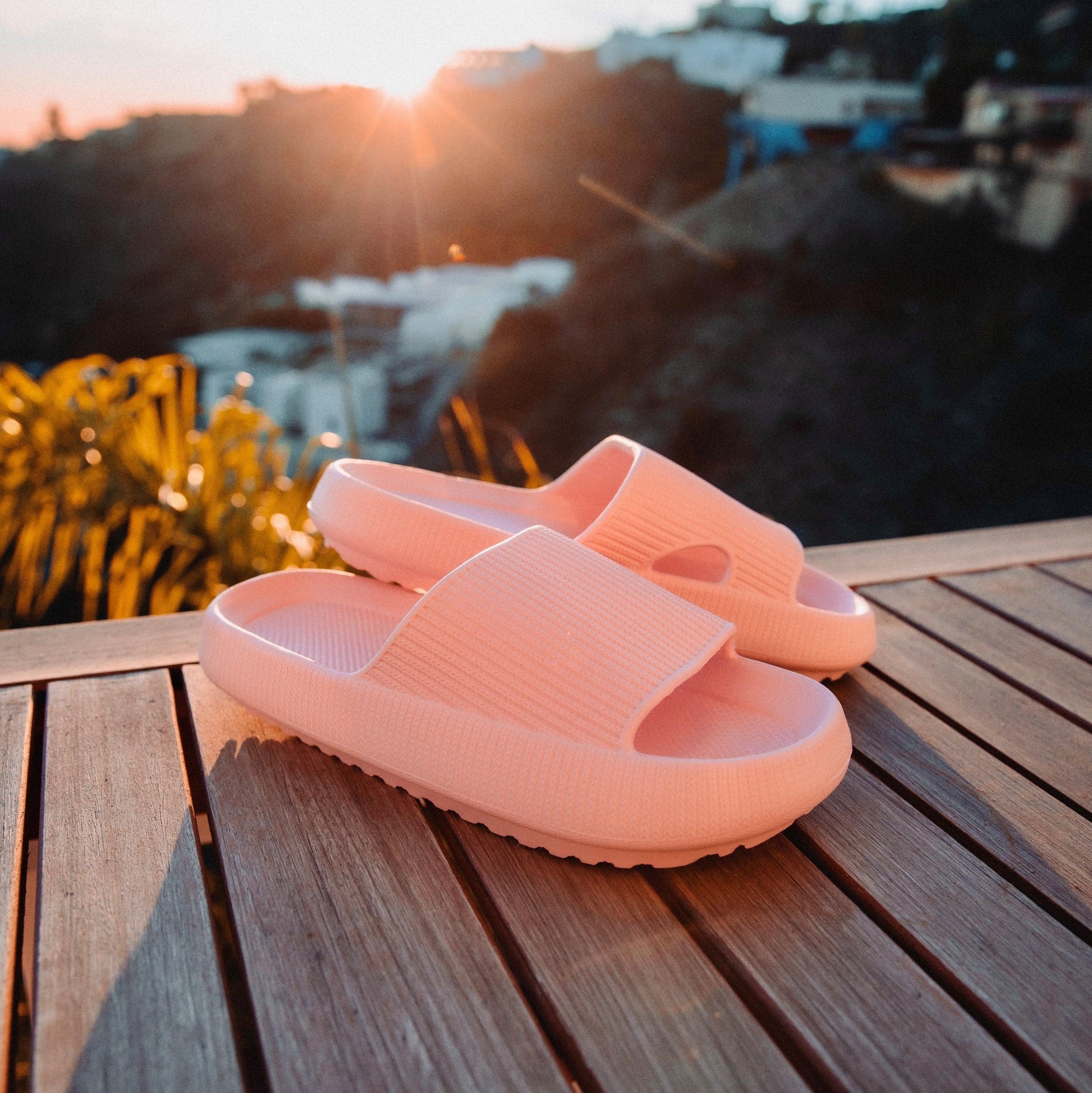 Men's pink slippers on wooden deck